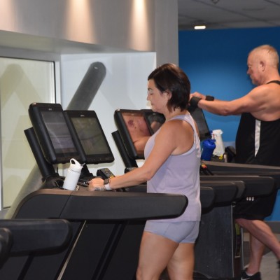 Man and woman using a treadmill in the gym